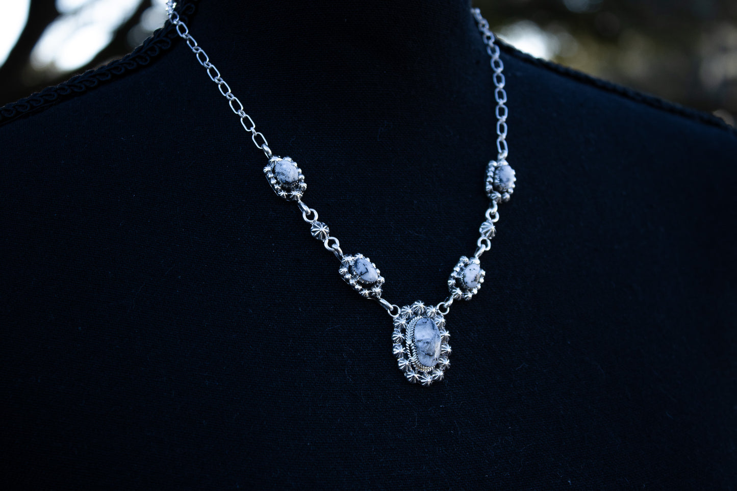 A close up of the necklace showing the 5 white buffalo turquoise stones and the Native American artist silver smithing work.