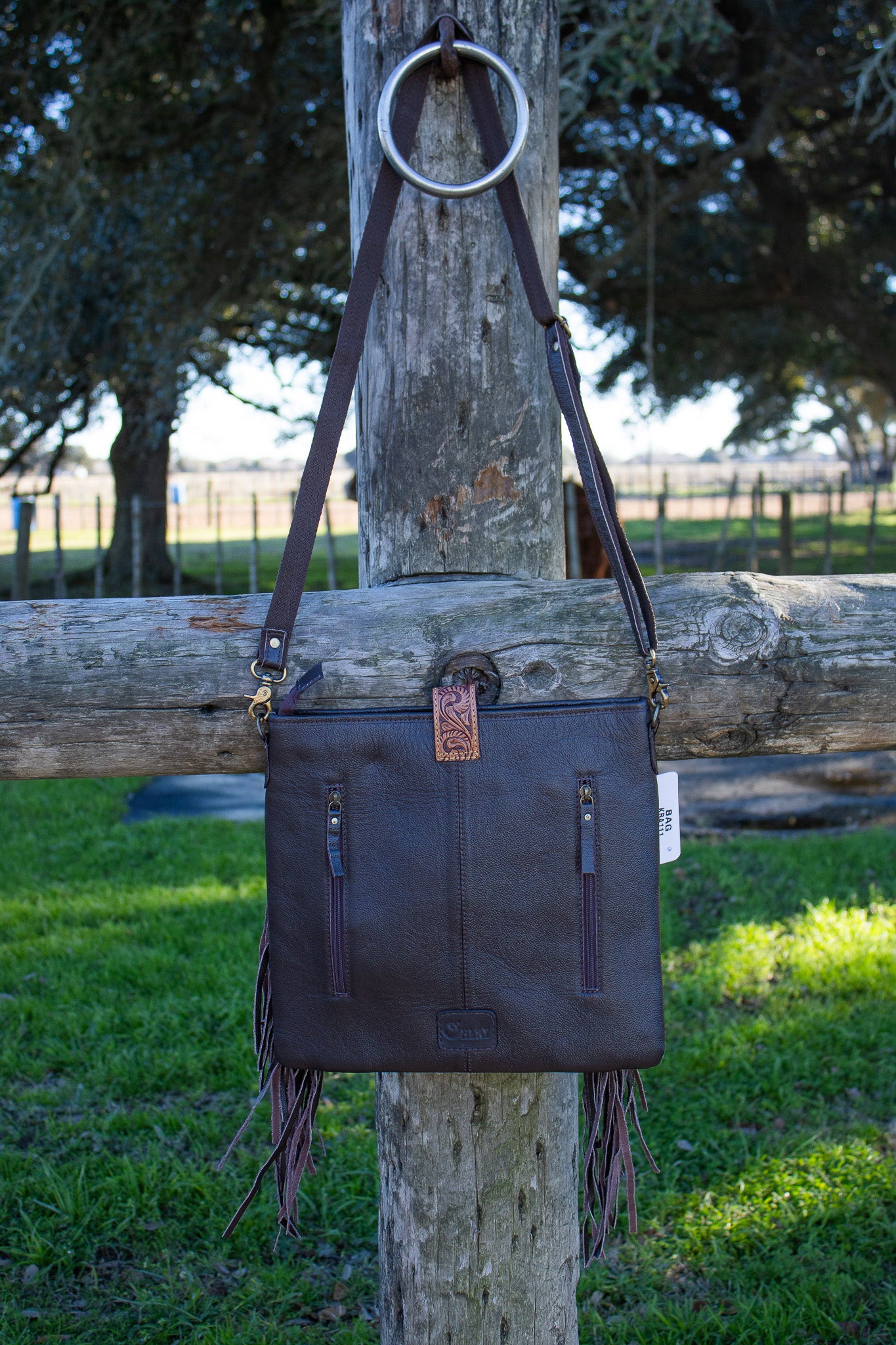 brown leather back of purse with two vertical zippers for concealed carry